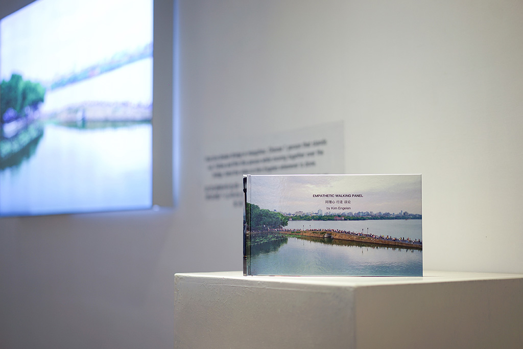 Kim Engelen, Bridge-Performance, Empathetic Walking Panel, light-box: 120x80x8 cm (47.24x31.50x3.15 inches), book: 17x30 cm (6.69x11.81 in), selfie-stick and drone video recording, 2018